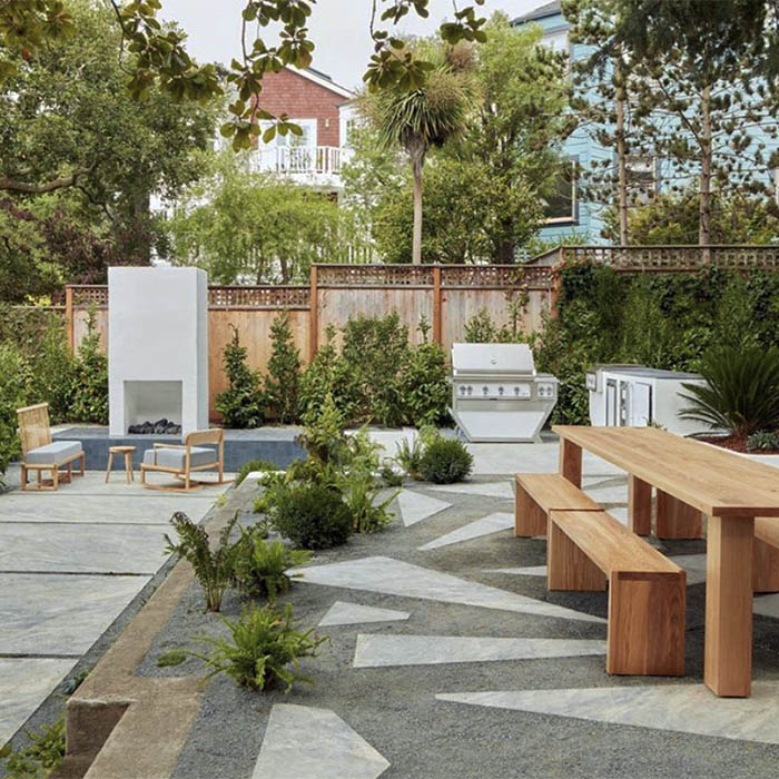 Landscape construction including fireplace, concrete pathways, grill, tables and chairs matching the San Francisco city modern style.